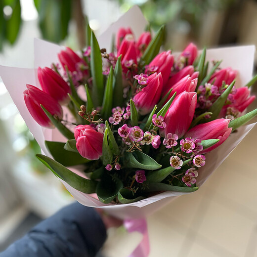 Bouquet of tulips with a wax flower in a decorative package