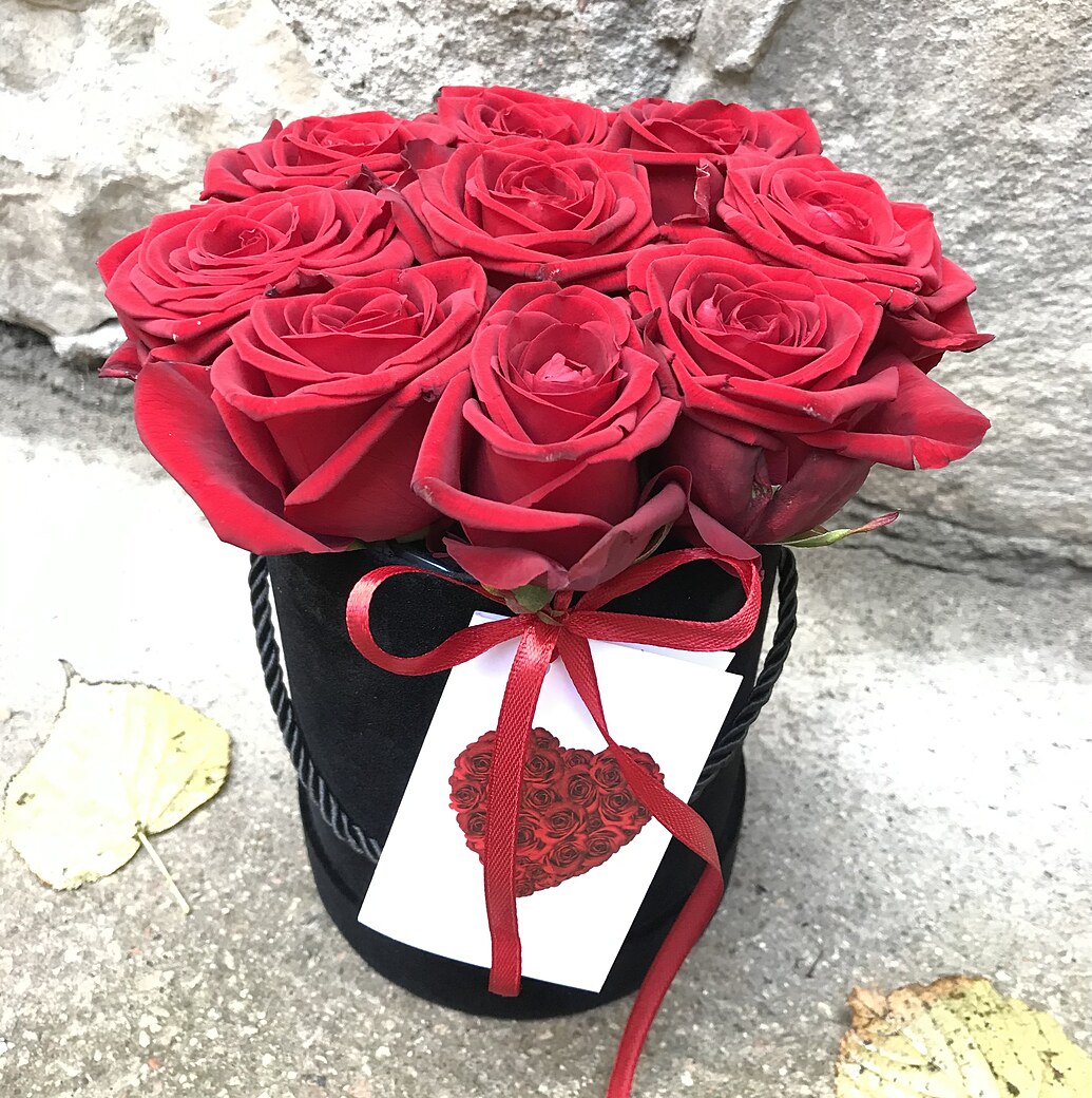 Красные розы в черной круглой коробке