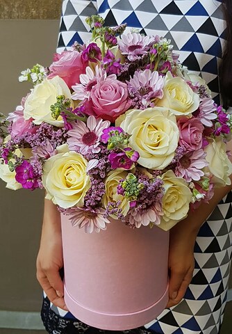Flower composition in summer colors in a cylindrical box
