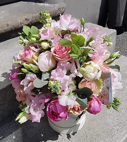 Composition of peony, roses and matthiola flowers in a box
