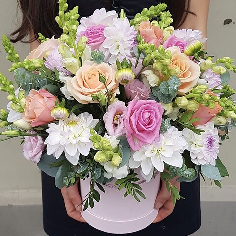 Close view of dahlias, pink and cream roses in a flower box